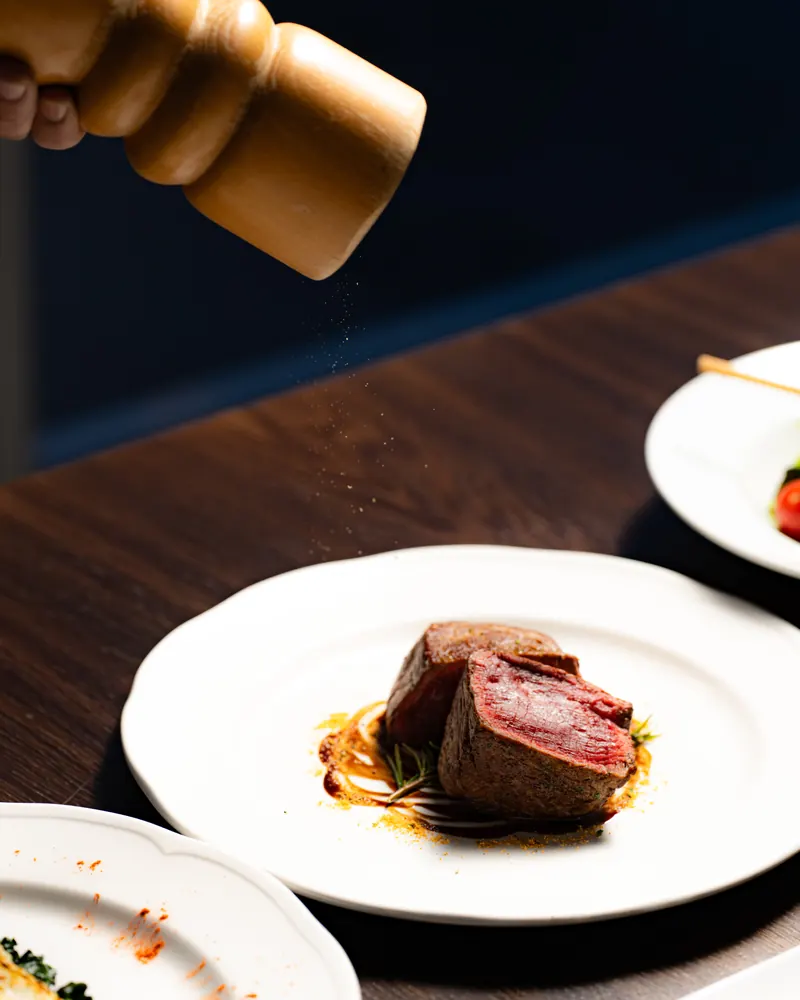 Grilled beef fillet seasoned with fresh pepper from a wooden mill