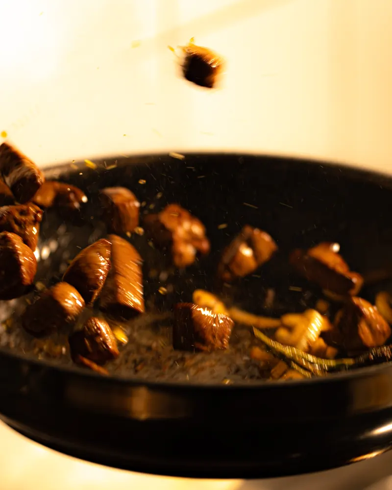Meat and onions tossed in a pan on the stove