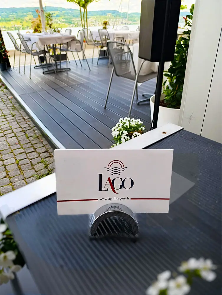 LAGO table card on a terrace table by the lake