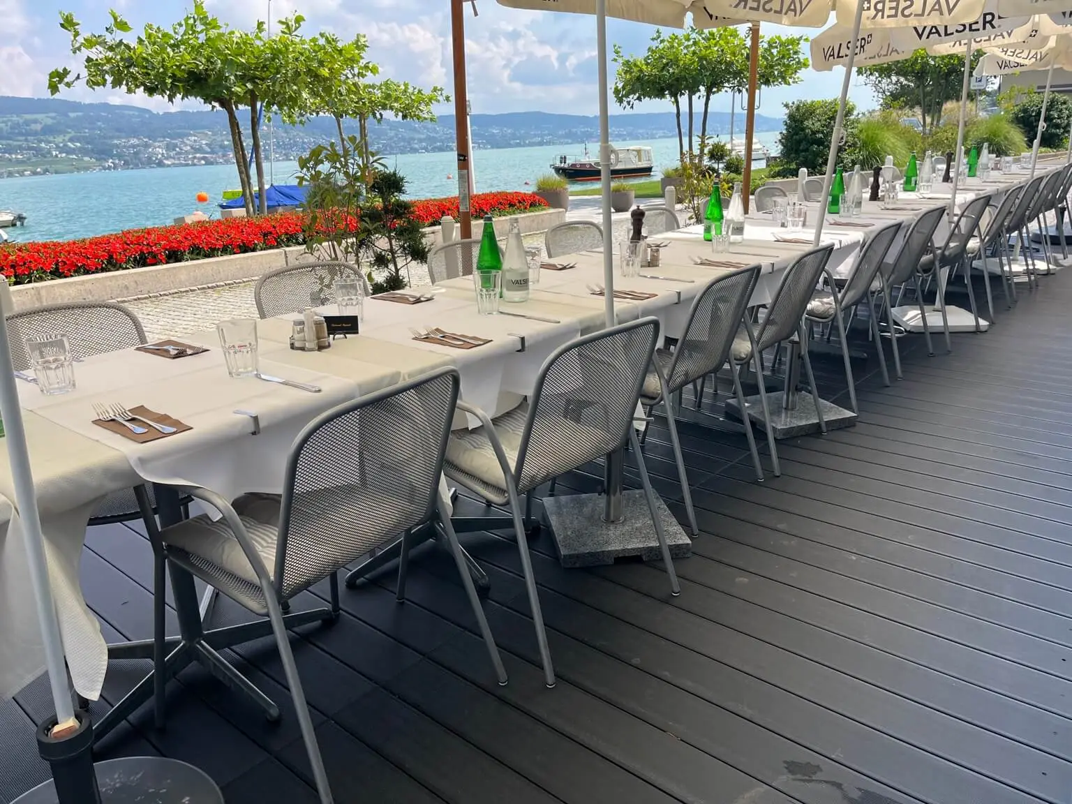 Long table on the wooden deck right on Lake Zurich