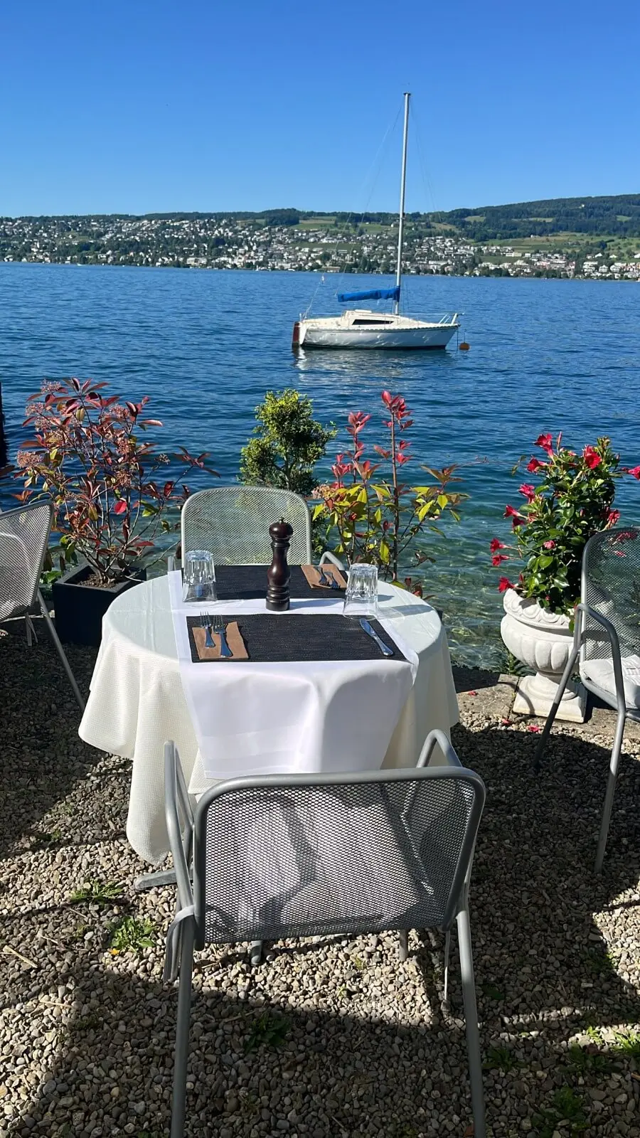 Table for two at the water with a sailboat on Lake Zurich