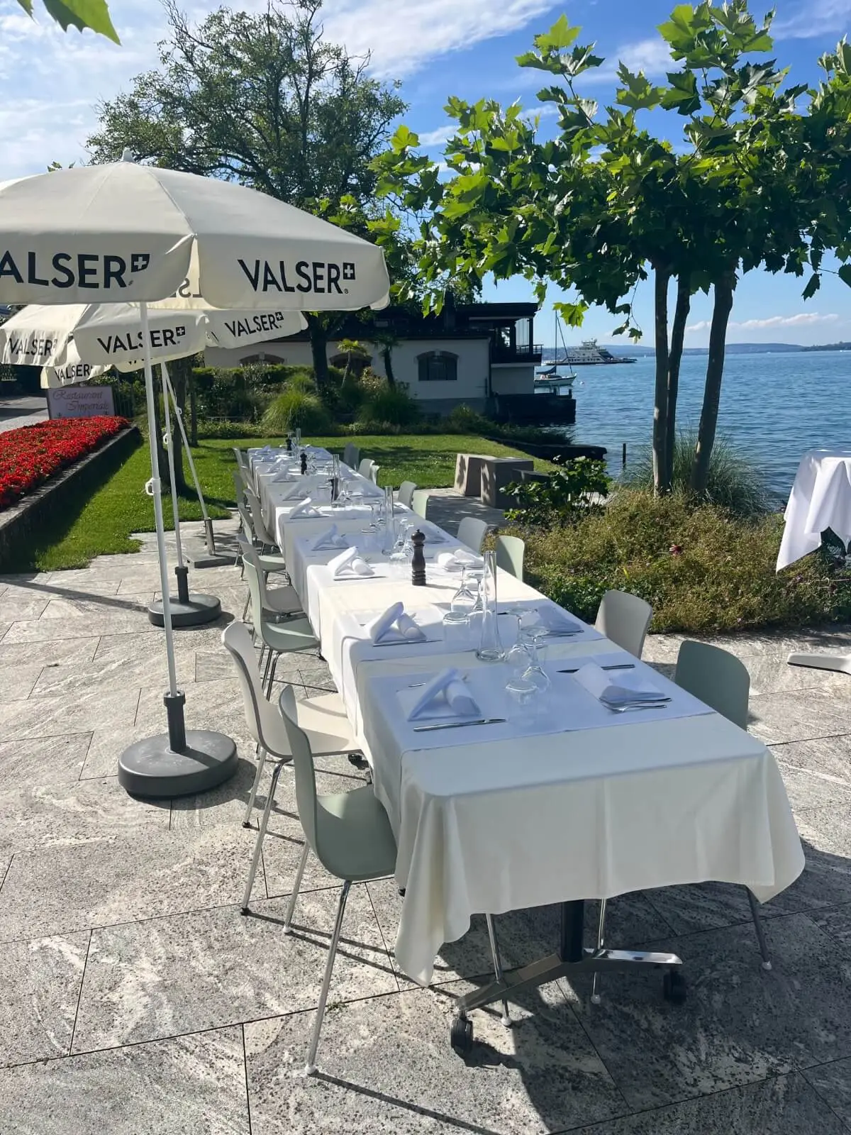 Long table set for a celebration on the lakeside terrace
