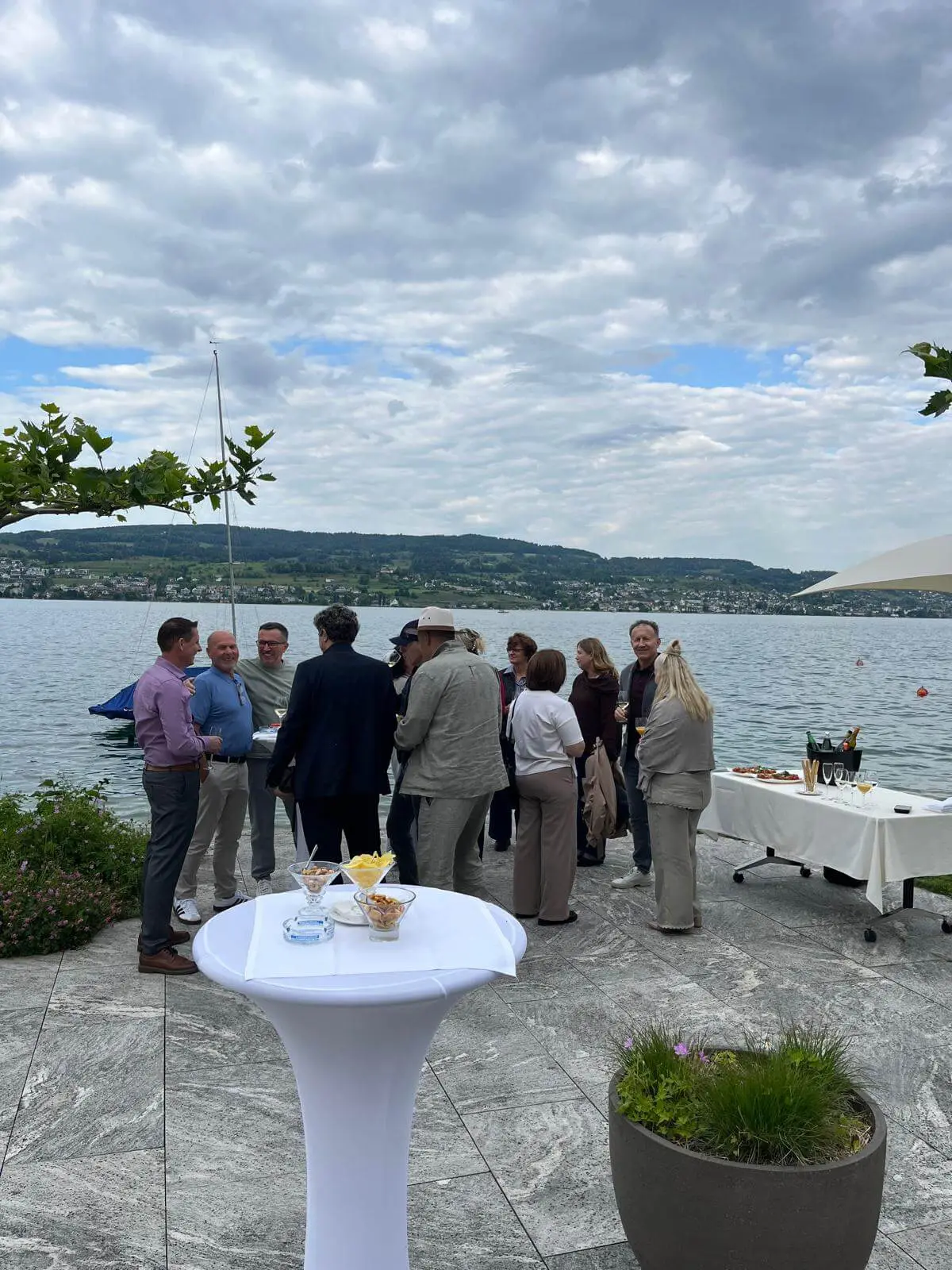 Guests at a standing apéro on the lakeside terrace